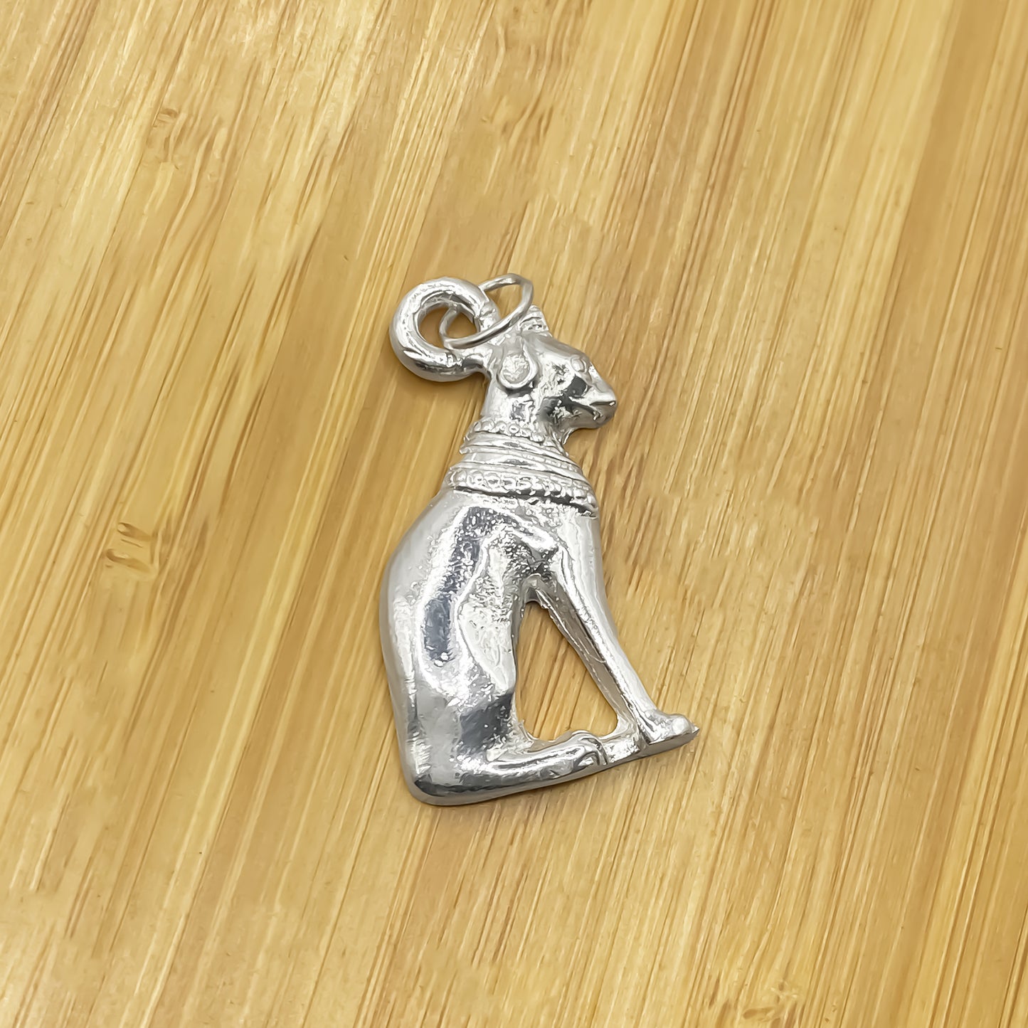 Close-up of Bast Cat Pendant on wooden background in silver or gold. Free Shipping, Mystical charm Protector