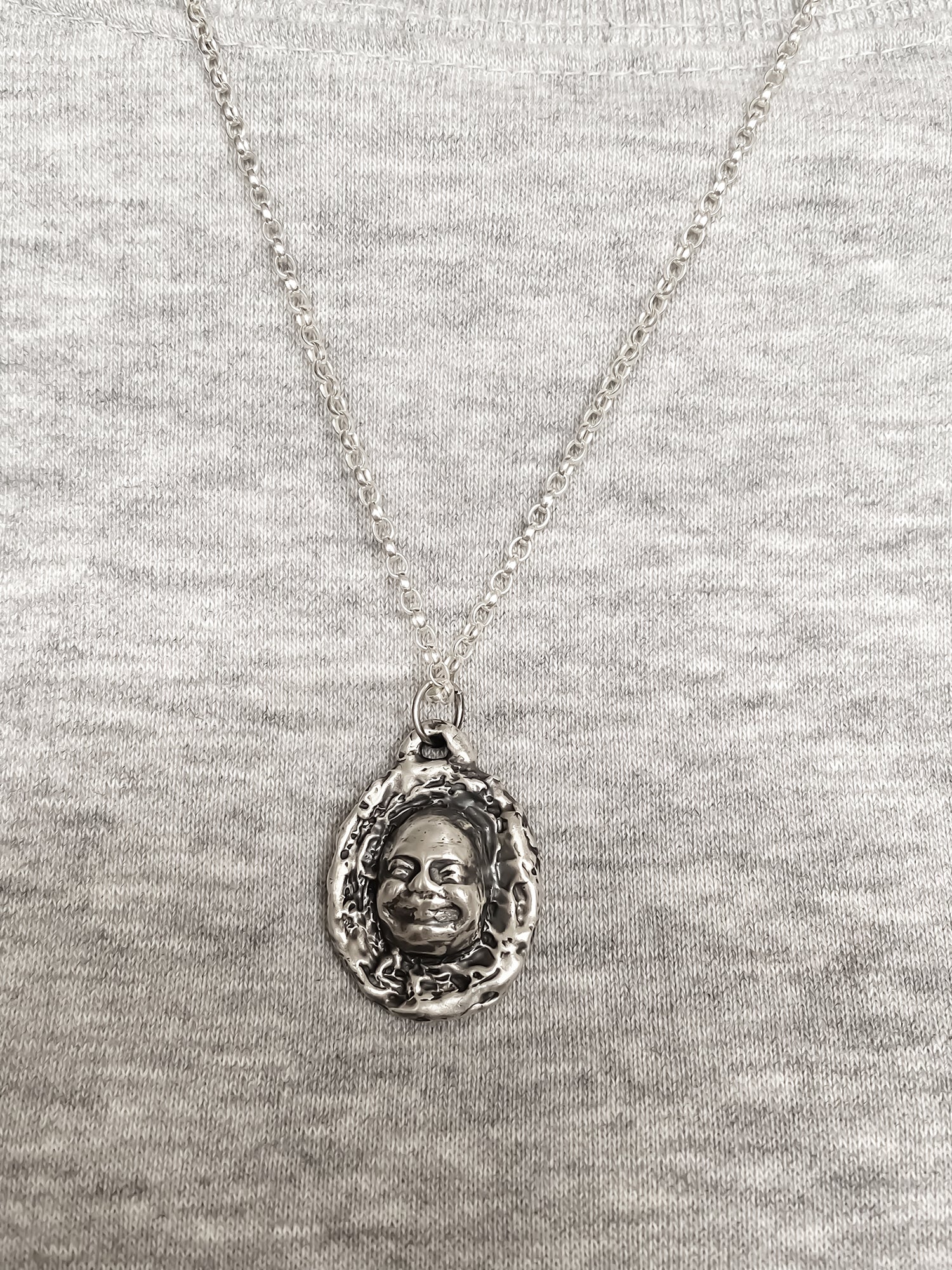 Happy Buddha Face Pendant styled with grey knit backdrop - happy buddha, spiritual, oxidised organic texture gold or silver free shipping