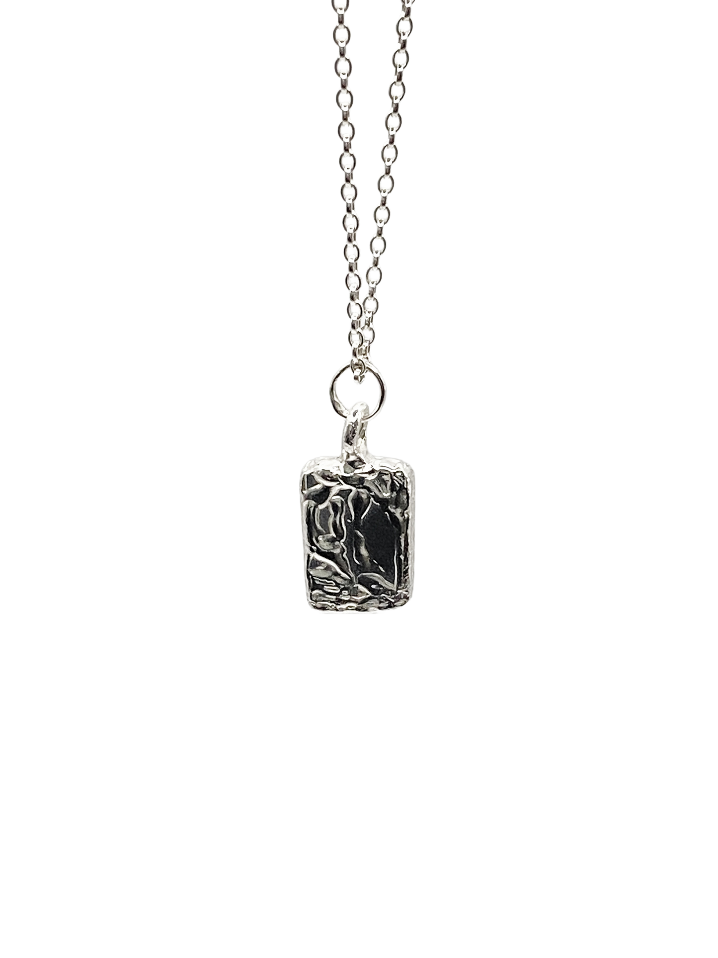Close-up of rectangular sculpted pendant on chain, textured silver, sleek and minimal design with delicate lines and free shipping