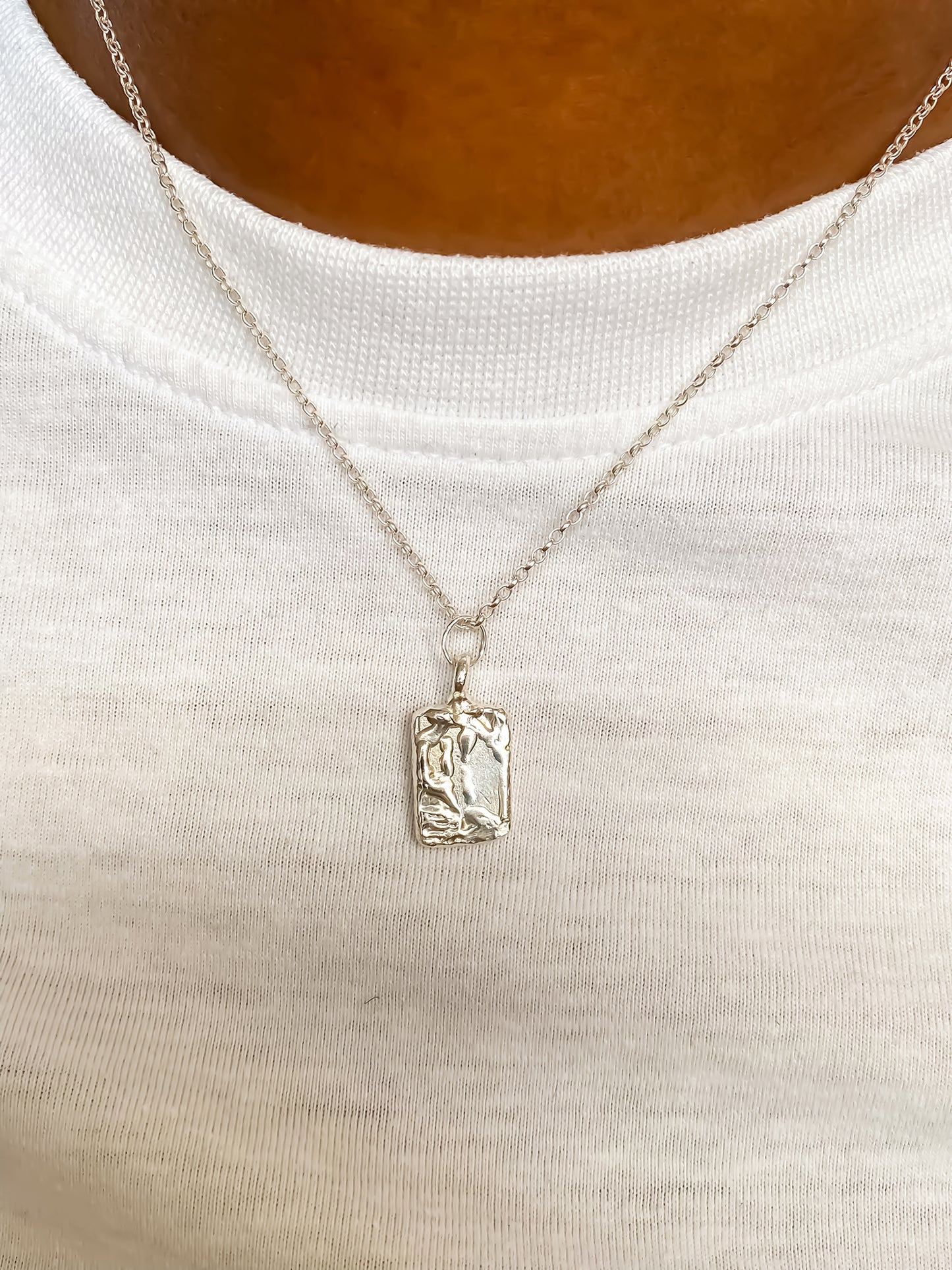 Silver rectangular sculpted pendant worn on neck, sleek and minimal textured style, delicate jewellery with free shipping