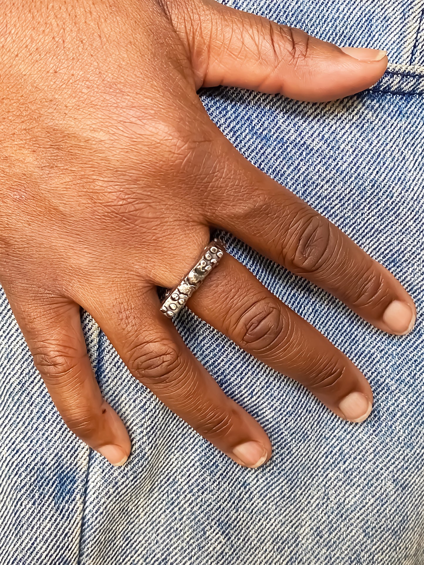 Slender unique Textured Ring oxidised gold or silver free shipping showcased on a hand with denim background