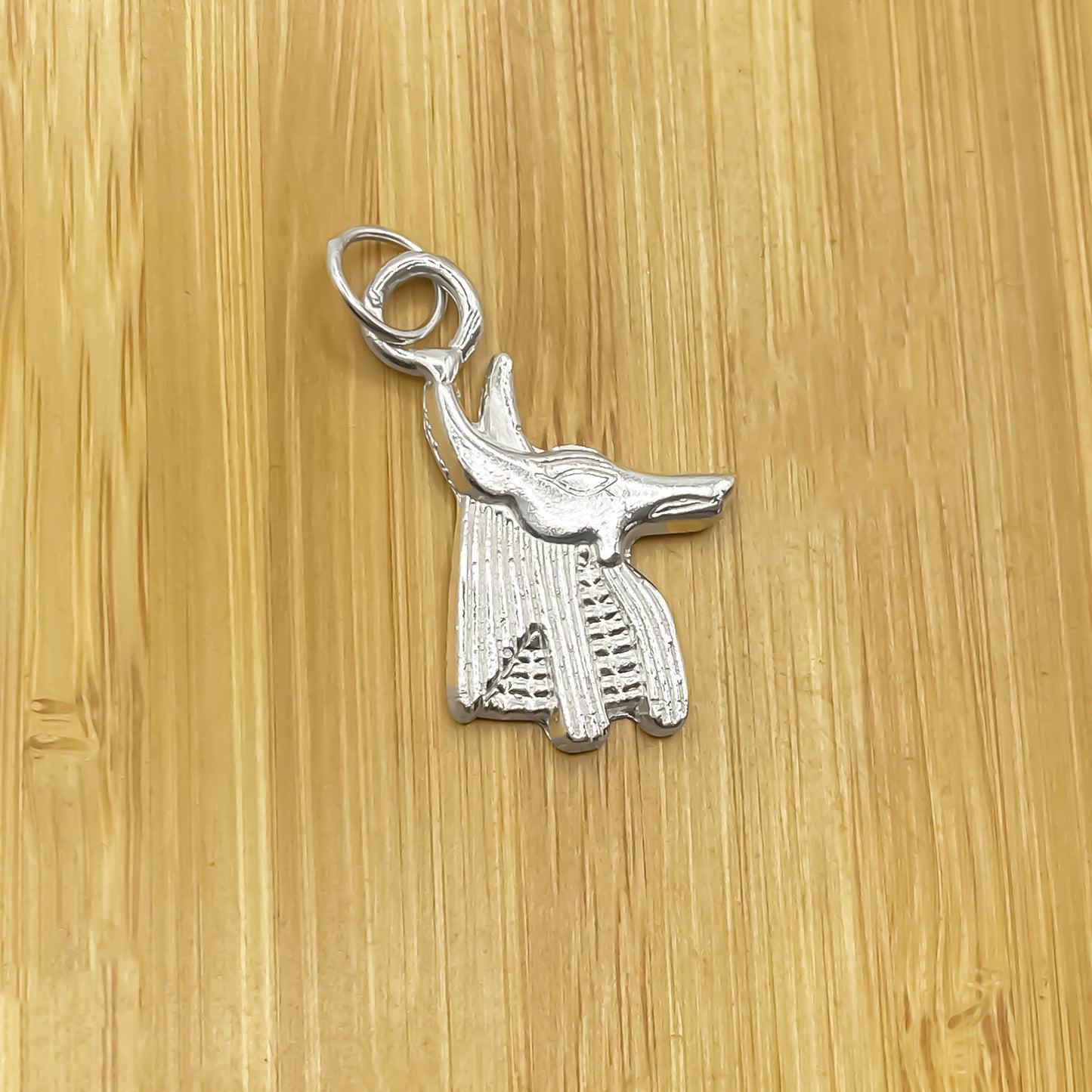 Anubis Pendant laid on wooden surface, silver Ancient Egyptian African Afterlife Guardian design,  silver or gold free shipping