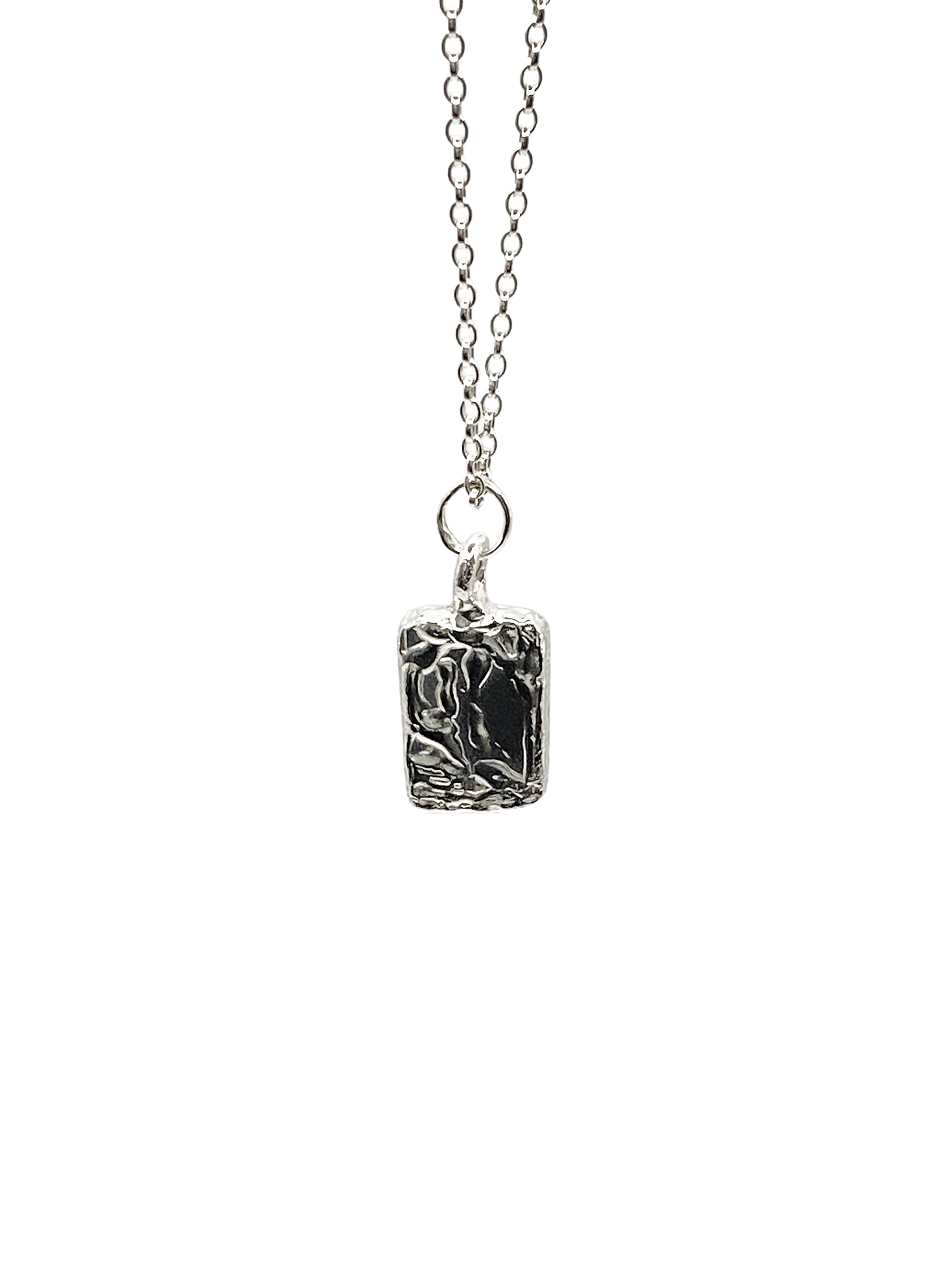Close-up of rectangular sculpted pendant on chain, textured silver, sleek and minimal design with delicate lines and free shipping
