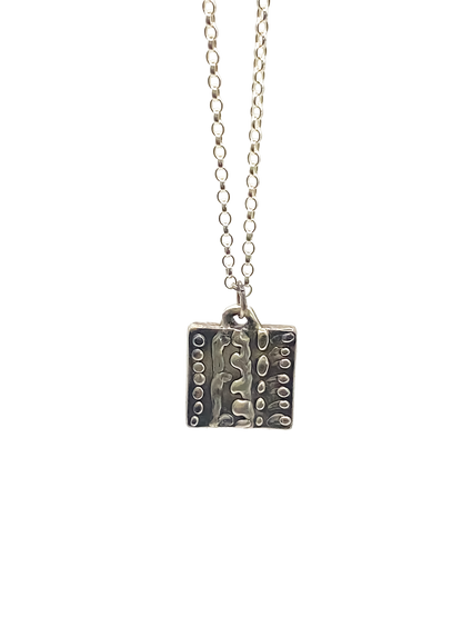 Close-up studio shot of Dotty Pendant in silver - textured, square happy buddha, oxidised organic texture gold or silver free shipping