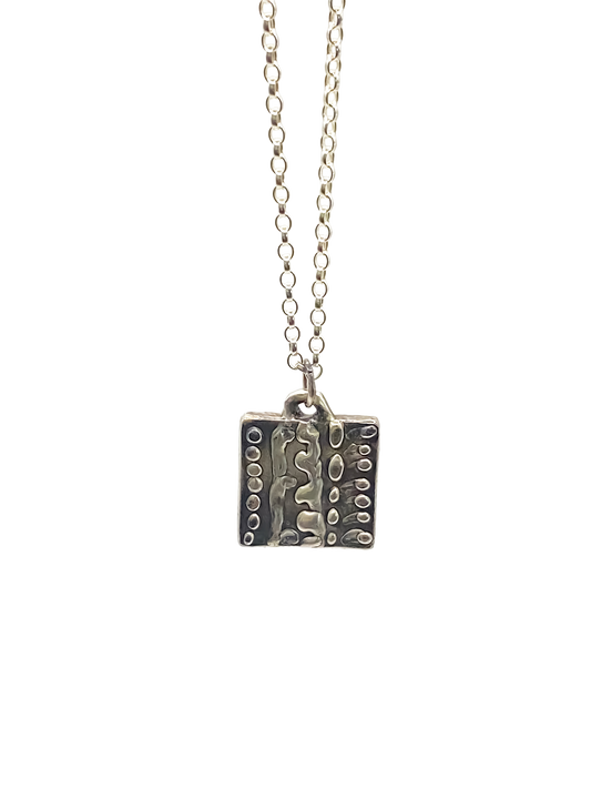 Close-up studio shot of Dotty Pendant in silver - textured, square happy buddha, oxidised organic texture gold or silver free shipping