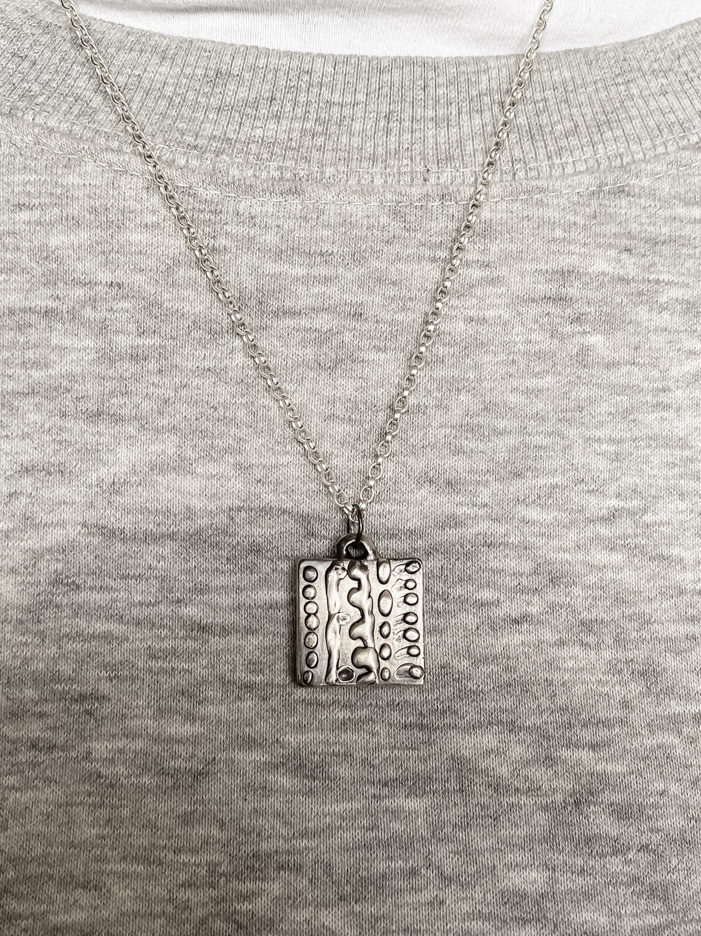 Dotty Pendant worn on grey knit for soft contrast - textured, square happy buddha, oxidised organic texture gold or silver free shipping