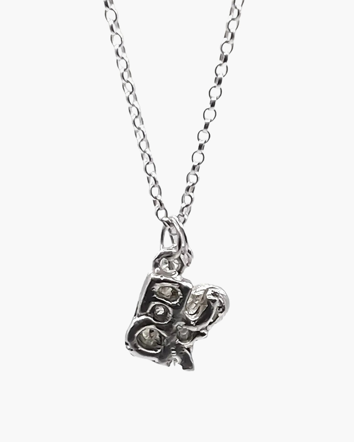 Close-up of the sterling silver Fuck + Love pendant