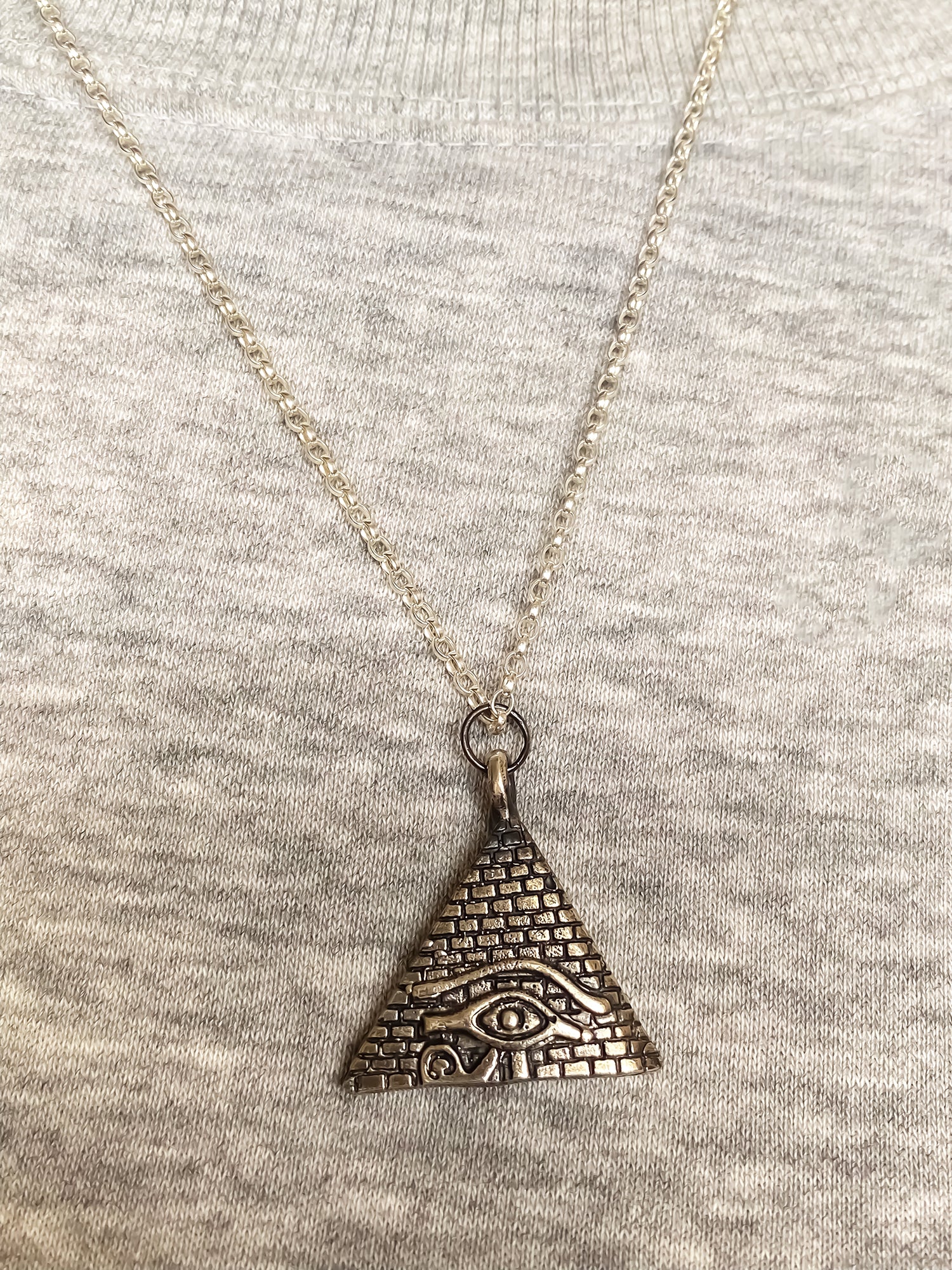 Geometric pendant featuring Eye of Horus and pyramid in oxidised silver or gold, ancient African design