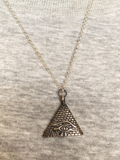 Geometric pendant featuring Eye of Horus and pyramid in oxidised silver or gold, ancient African design