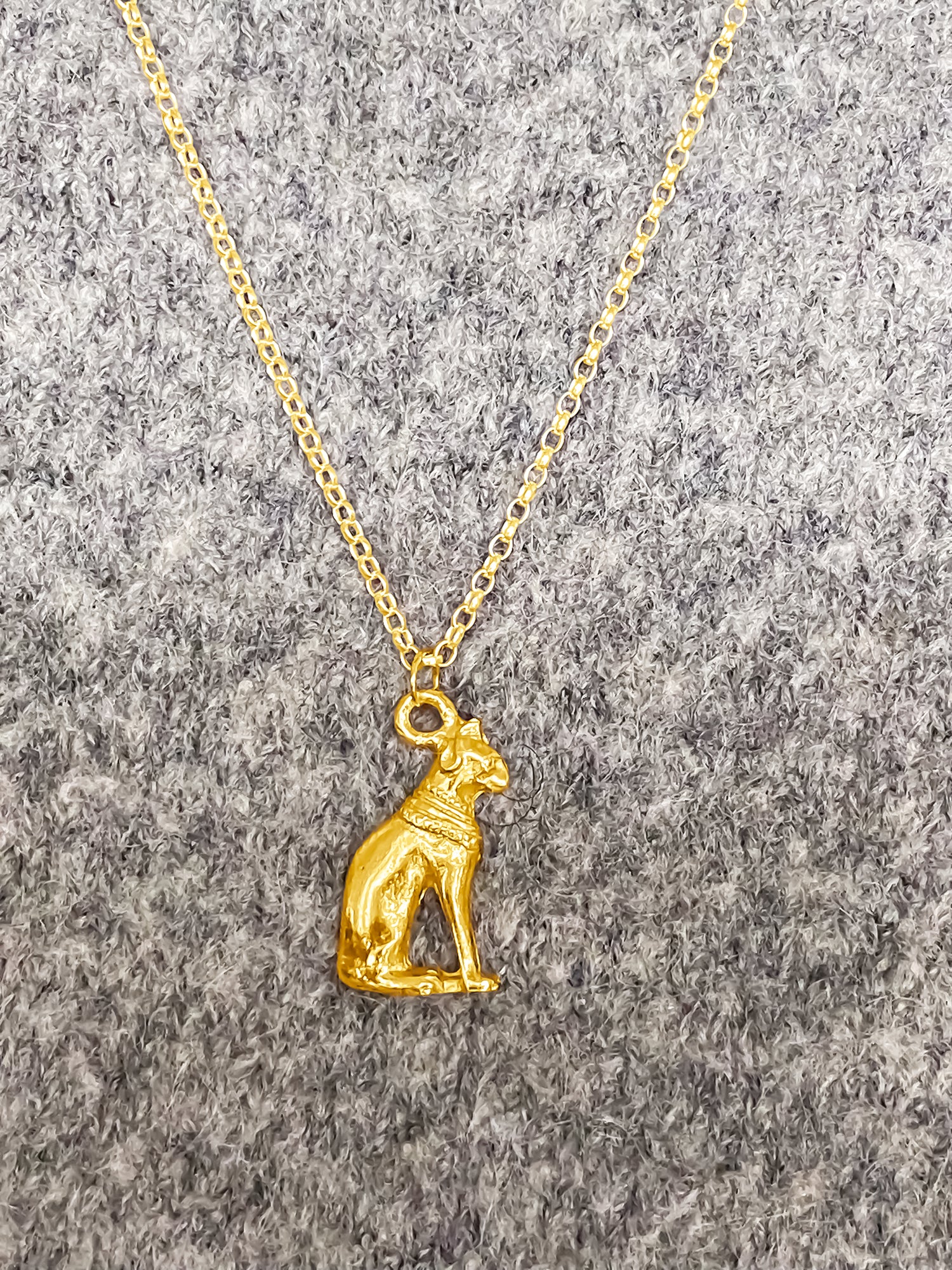 Gold Bast Cat Pendant on wool top, Egyptian inspired jewellery representing Bastet’s mystical charm. Free UK shipping with MOCA Jewellery.