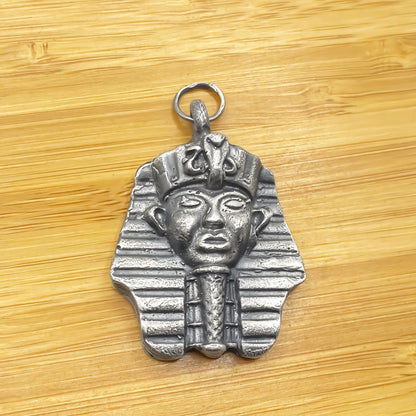 Pharaoh Pendant laid on wood showing texture - oxidised Egyptian African gold or silver free shipping