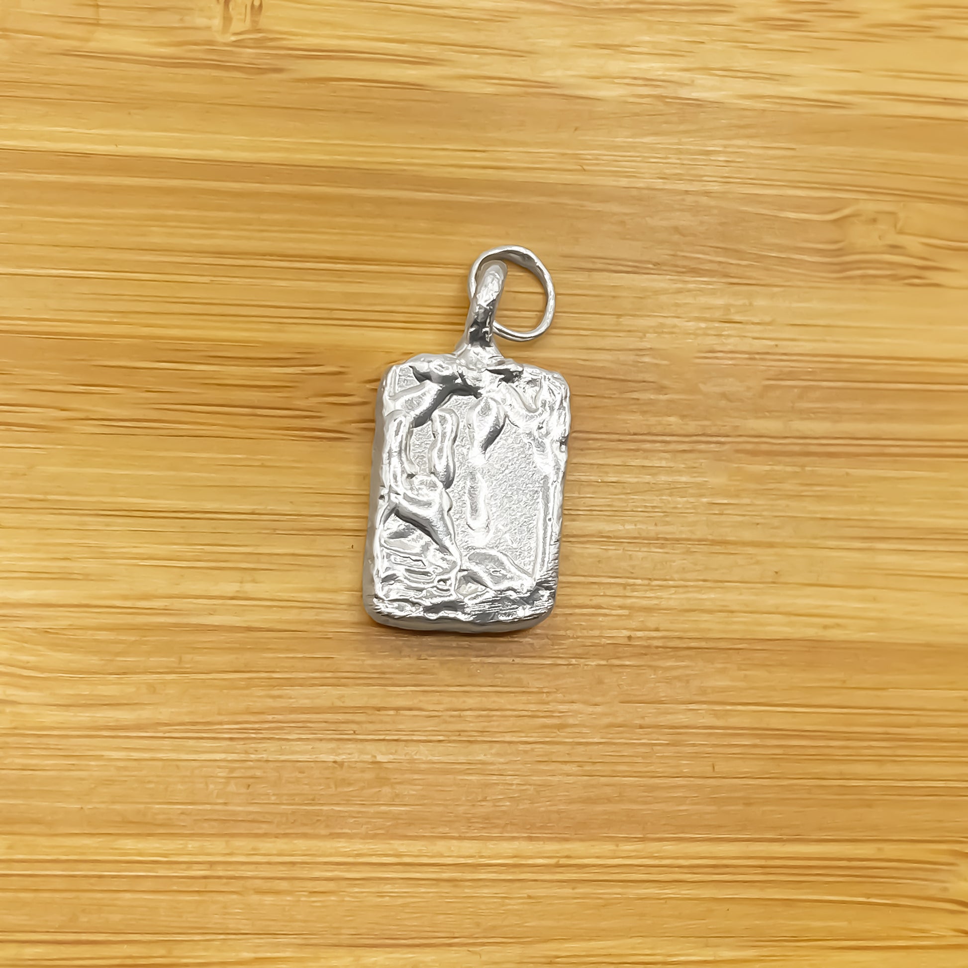Rectangular sculpted pendant on wood background, sleek textured silver or gold with delicate minimal style and free shipping