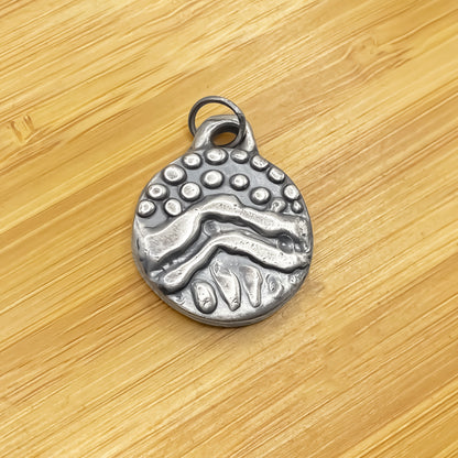 Round Dotty Pendant laid flat on wood for contrast - textured, happy buddha, oxidised organic texture gold or silver free shipping