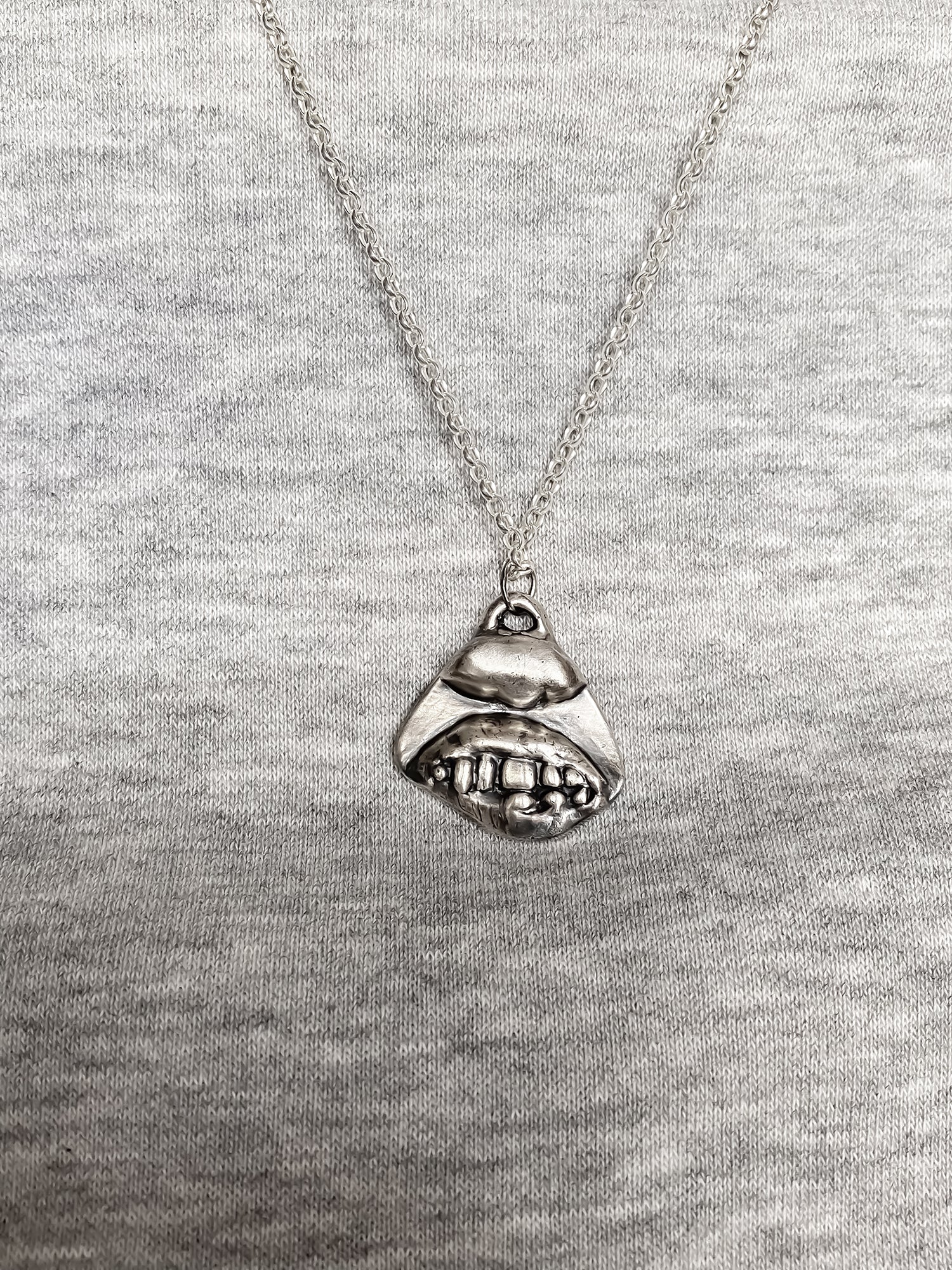 Smiler Pendant worn over grey knit for everyday styling - smile mouth lips teeth charming oxidised organic texture gold or silver free shipping